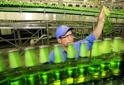 A worker monitors a beer product line at  Tsingtao Brewery Company Limited in Jiujiang, Jiangxi province, May 19, 2014. [Photo provided to China Daily]   