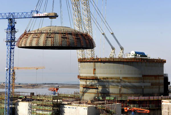 A steel dome is hoisted onto the No 1 reactor at Haiyang nuclear power plant in Shandong province in March 2013. [Photo/Xinhua]