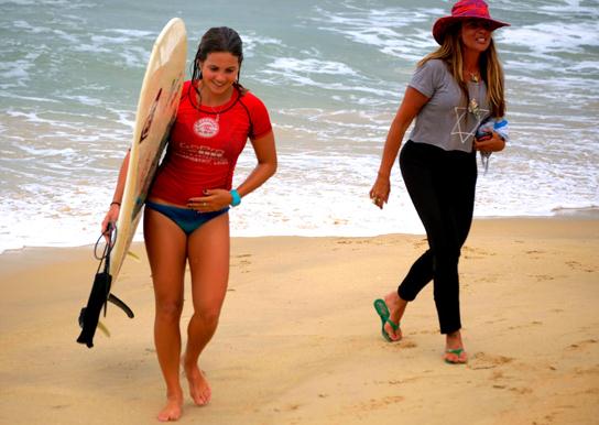A surfer walks on a beach in Wanning, Hainan province, in December. WANG FUCHUN/CHINA DAILY  