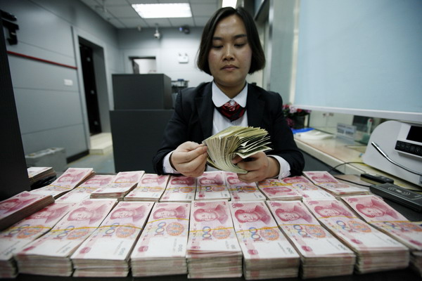 A bank employee counts cash at an outlet of Industrial and Commercial Bank of China in Huaibei, Anhui province. Difficulties are increasing for the central bank to manage liquidity. [Photo/China Daily]