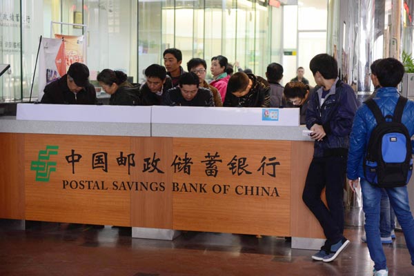Customers at a Postal Savings Bank of China Co branch in Qingdao, Shandong province. The bank has about 40,000 outlets nationwide and more than 470 million customers. [Photo/China Daily]  