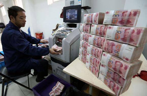 A bank employee prepares bank notes at an Industrial and Commercial Bank of China Ltd cash center in Wuxi, Jiangsu province. (Photo/provided to China Daily)  