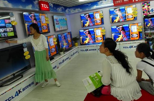 Customers check TCL TV sets at an outlet in Yichang, Hubei province. TCL's overseas market accounted for 46.6 percent of all its businesses last year. Photo: for China Daily/Liu Junfeng)