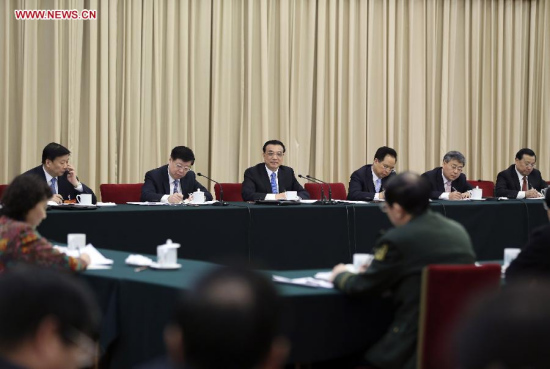 Chinese Premier Li Keqiang (3rd L, back), also a member of the Standing Committee of the Political Bureau of the Communist Party of China Central Committee, joins a panel discussion with deputies to the 12th National People's Congress (NPC) from east China's Shandong Province during the third session of the 12th NPC, in Beijing, capital of China, March 6, 2015. (Xinhua/Ding Lin)