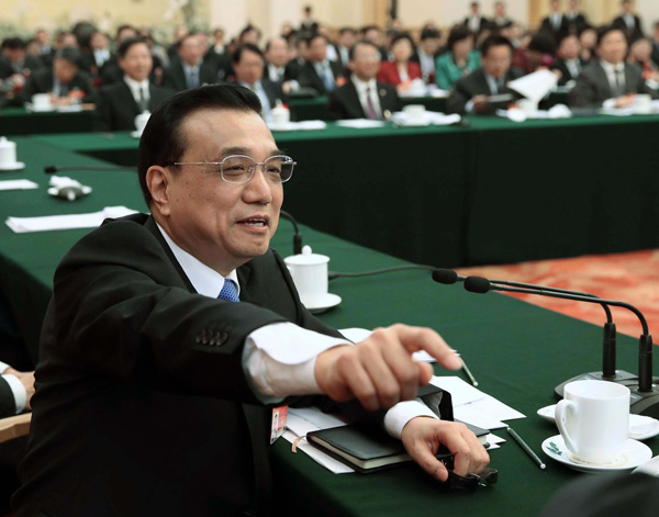 Premier Li Keqiang invites an NPC deputy from Shandong province to give his opinions of the Government Work Report on Friday. Li extended a meeting to hear from Wang Tingjiang (right), who had raised his hand as the meeting was closing. (Photo: China Daily/Wu Zhiyi)