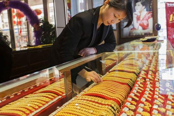A saleswoman sorts gold items at a jewelry shop in Lianyungang, Jiangsu province. China is the world's biggest producer and second-largest consumer of gold. (Photo: Si Wei/For China Daily)  