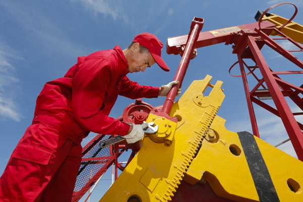 An employee of a subsidiary of CNPC's oilfield operations in the Xinjiang Uygur autonomous region inspects pumping equipment. CNPC will make available a 49 percent stake in its oilfields in Xinjiang to other investors. (Zhang Yuwei / Xinhua)