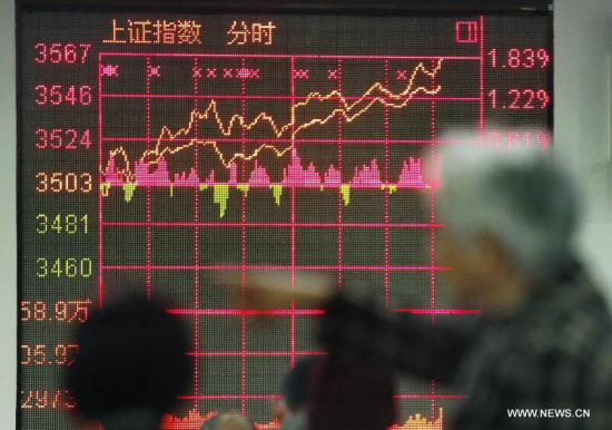 Investors look through stock information at a trading hall of a securities firm in Shanghai, east China, March 18, 2015. (Photo: Xinhua/Ding Ting)