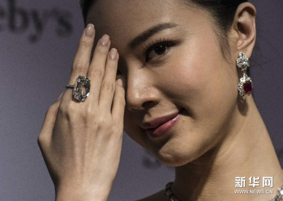 A model shows a diamond ring worth 34 mln to 40 mln HK dollars on pre-auction display in Hong Kong, March 19, 2015. (Photo/Xinhua)