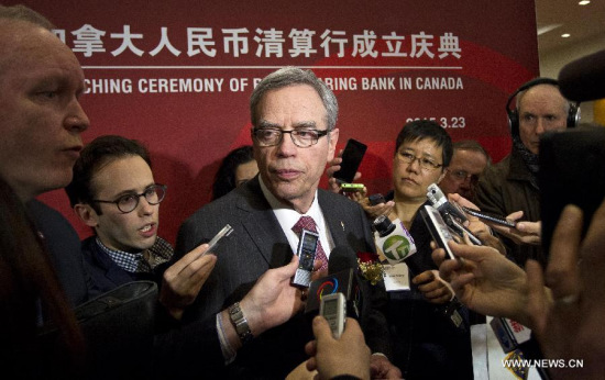 Canadian Finance Minister Joe Oliver (C) speaks to reporters during the launching ceremony of China's ICBC RMB clearing bank in Canada, in Toronto March 23, 2015. ICBC Canada, a Renminbi clearing bank, was officially launched here on Monday, becoming the first RMB trading hub in North America. (Xinhua/Zou Zheng)