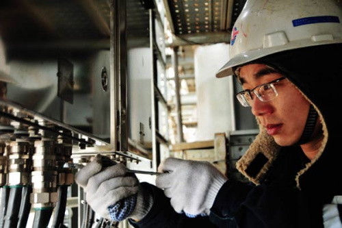 A worker connects electric cables at an offshore oil engineering company in Qingdao, Shandong province. The Asian Development Bank said China's GDP growth may slow to 7.2 percent this year from 7.4 percent in 2014.(Photo: Yu Fangping/China Daily)