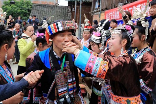 Women of the Dong ethnic group in Liuzhou, Guangxi Zhuang autonomous region, greet tourists. China's travel and tourism sector will contribute 6.24 trillion yuan, or 9.5 percent of the country's GDP this year.(Photo: Tan Kaixing/For China Daily)