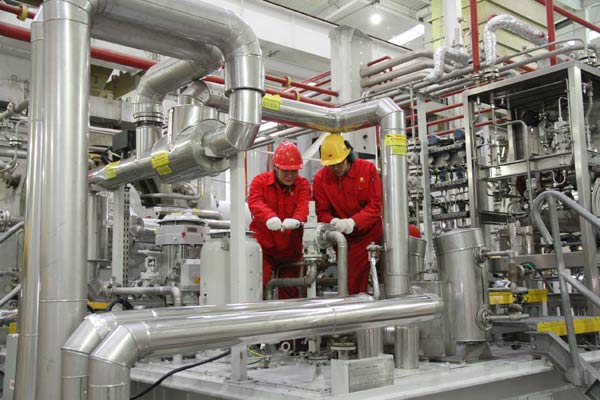 Workers of PetroChina Co check facilities in Qinshui county, Shanxi province. The company reported a 17.3 percent decline in net profit last year amid falling oil prices. (CHEN YUANZI/FOR CHINA DAILY)