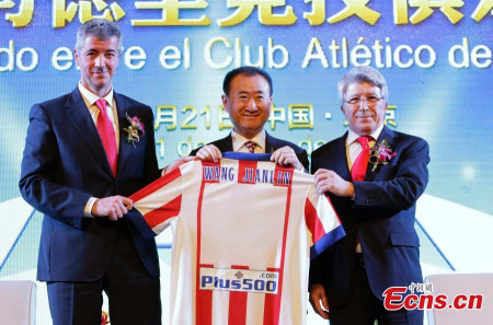 Wang Jianlin (M), chairman of the Dalian Wanda property group, together with Atletico Madrid CEO Gil Marin (L) and club president Enrique Cerezo (R), hold a jersey which features Wang’s name on the back at a signing ceremony in Beijing on Jan 21, 2015. [Photo/Agencies] 