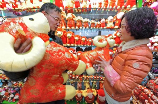A shop owner in Yiwu, the largest wholesale market for small commodities in Zhejiang province, shows to a customer mascots relating to the Year of the Ram. Yiwu has been increasing trade links with countries along the Silk Road Economic Belt and 21st Century Maritime Silk Road. (Photo/Xinhua)
