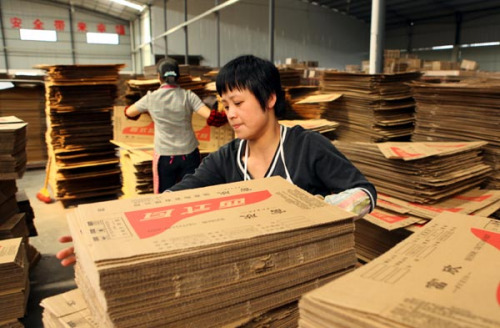 A cardboard-box maker in Huaying, Sichuan province. The paper industry is on the upswing in China due to rising demand from e-commerce companies. (Photo/China Daily)  