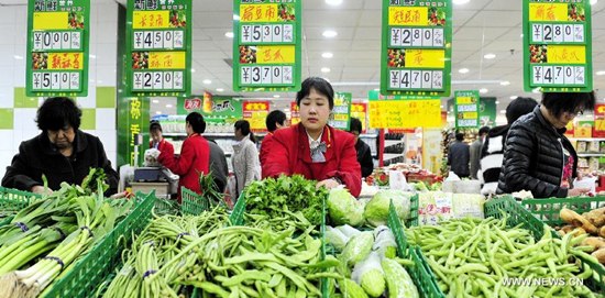 A staff member places vegetables at a supermarket in Cangzhou, capital of north China's Hebei Province, April 9, 2015. China's consumer price index (CPI), a major gauge of inflation, rose 1.4 percent from a year earlier in March, according to the data released by the National Bureau of Statistics on Friday. (Xinhua/Mou Yu)