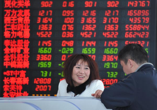 Investors at a securities firm in Fuyang, Anhui province, on Monday. The benchmark Shanghai Composite Index rose 2.17 percent to close at 4,121.17 points. (Photo/China Daily)