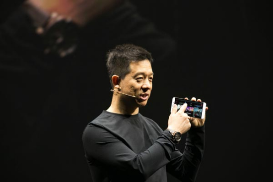 Jia Yueting, founder and chief executive of LeTV, shows the company's first smartphone at a news conference in Beijing on Tuesday. (Photo/China Daily)