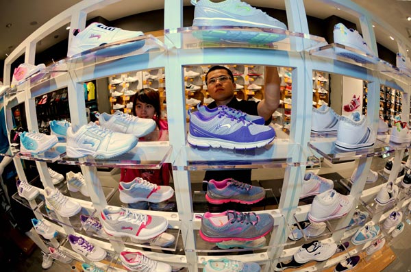 Potential buyers examine Guirenniao sportshoes at a shop in Beijng. (Photo/China Daily)