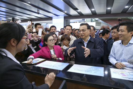 Premier Li Keqiang visits a service center in Xiamen, part of the Fujian Pilot Free Trade Zone, on Wednesday. (China News Service/Liu Zhen)