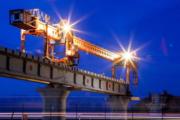 Engineers work at a railway bridge near Hami, Xinjiang Uygur autonomous region, on April 20, 2015. The country's new railway development fund has raised 8.2 billion yuan, while top oil refiner China Petroleum & Chemical Corp has attracted more than 100 billion yuan of private capital to restructure the company's business. (Photo: China Daily/Cai Zengle)