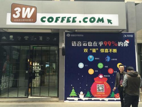 Two people talk in front of 3W Coffee in Zhongguancun, Beijing. It is possible to sit in the shop for a whole day by just ordering a 19-yuan espresso and enjoy its free Wifi service. (Photo/China Daily)