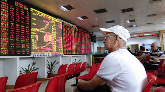 Investors check share prices at a brokerage in Haikou, Hainan province, on Monday. Reports on planned State-owned enterprise mergers pushed the benchmark Shanghai stock index to a seven-year high of 4,527.40 points. (Photo/China Daily)