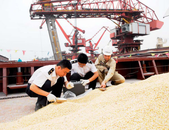 Customs officers inspect imported corn at a port in Lanshan, Shandong province. Provided to China Daily  