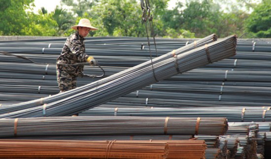 A worker guides the transport of steel products at a market in Haikou, capital of Hainan province. First-quarter steel exports surged 40.7 percent to 25.78 million metric tons as mills responded to weak domestic demand and falling prices. (Photo/China Daily)