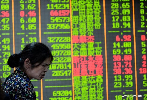 A stock investor follows information in a stock trading hall in Hangzhou, capital city of east China's Zhejiang Province, May 5, 2015. Chinese shares tumbled on Tuesday, with the benchmark Shanghai Composite Index down by 4.06 percent to finish at 4,298.71 points, and the Shenzhen Component Index fell 4.22 percent to close at 14,233.1 points. (Xinhua/Long Wei)