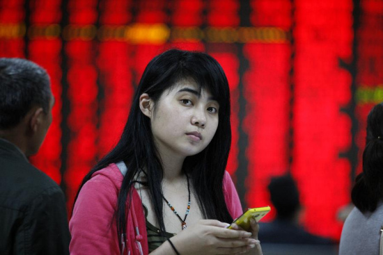 An investor follows information at a stock trading hall in Huaibei City, east China's Anhui Province, May 11, 2015. Chinese shares ended higher on Monday, with the benchmark Shanghai Composite Index up 3.04 percent, or 127.67 points, to finish at 4,333.58 points. The Shenzhen Component Index gained 3.2 percent, or 463.63 points, to close at 14,944.88 points. (Xinhua/Xie Zhengyi)
