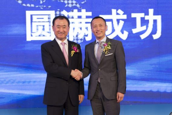 Wang Jianlin (left), chairman of Dalian Wanda Group Co, and Yu Liang, CEO of China Vanke Co Ltd, shake hands after the two real estate developers inked a strategic cooperation agreement on Thursday in Beijing. Photo/China Daily