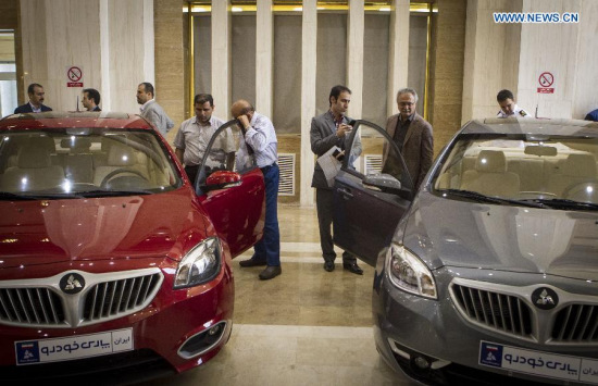 Iranian customers watch model cars of the joint assembly lines of Iran's SAIPA and China's Brilliance Auto in Tehran, Iran, on May 19, 2015. SAIPA, Iran's second largest carmaker, launched two assembly lines on Tuesday in cooperation with China's Brilliance Auto. (Xinhua/Halabisaz) 