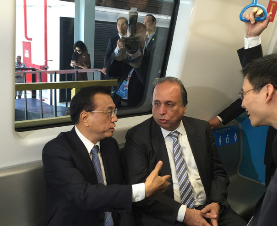 Premier Li Keqiang takes a ride on the new subway Line 4 with Rio de Janeiro Governor Luiz Fernando de Souza on Wednesday. The train was made by China's CNR Corp. (Provided to China Daily)