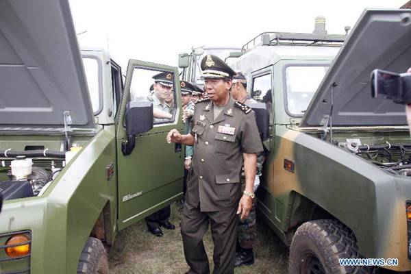 Cambodian Deputy Prime Minister and Defense Minister Tea Banh (front) inspects vehicles provided by China at the Infantry Institute in Kampong Speu Province, Cambodia, May 23, 2015. China delivered army vehicles and spare parts to Cambodia on Saturday for a training program in auto-repair class at the Infantry Institute, officials said. (Photo: Xinhua/Sovannara)