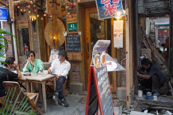 Customers sitting outside a cafe built after the renovation of an old house in Shanghai. An increasing number of young well off people in the city like small and high end units because they spend more time outside than at home. (Photo/China Daily)