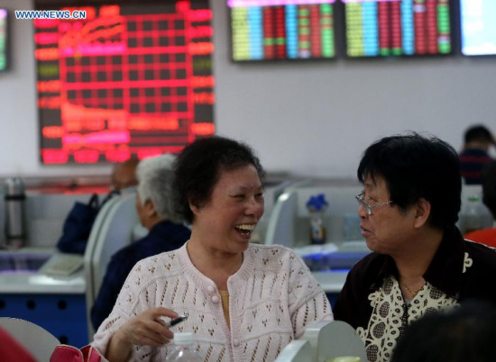 Stock investors follow information in a stock trading hall in east China's Shanghai, May 26, 2015. Chinese stocks rallied for the sixth successive day to close at a fresh seven-year high on Tuesday, with the benchmark Shanghai Composite Index surging 2.02 percent, or 97.1 points, to finish at 4,910.90 points. The Shenzhen Component Index gained 3.38 percent, or 552.42 points, to close at 16,903.47 points. (Xinhua/Pei Xin) 
