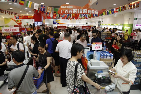 Customers browse bonded products at a Guangzhou Grandbuy store. The company, the largest department-store chain in the city, has opened cross-border e-commerce experience sections in three stores that adopt the online-to-offline mode. (Photo/China Daily)