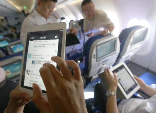 Passengers use WiFi services to surf Internet on mobile gadgets on a flight of China Eastern Airlines. (Photo/China Daily)