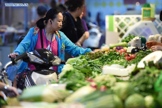 Residents purchase vegetables at a market in Zhengzhou, capital of central China's Henan Province, June 8, 2015. China's consumer price index (CPI), a main gauge of inflation, grew 1.2 percent year on year in May, the National Bureau of Statistics announced on Tuesday. (Photo: Xinhua/Li Bo)