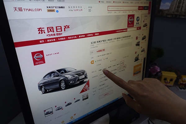 A potential customer browses vehicles online at Tmall.com. Online car sales platforms are challenging traditional dealer networks. (Photo/China Daily)