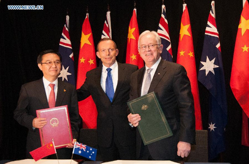 China's Commerce Minister Gao Hucheng (L) and Australia's Trade Minister Andrew Robb (R) pose for photos with Australian Prime Minister Tony Abbott after signing the China-Australia Free Trade Agreement at the National Gallery in Canberra June 17, 2015. (Photo: Xinhua/Justin Qian)