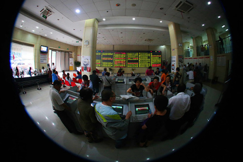 Investors monitor share prices at a securities brokerage in Nantong, Jiangsu province, on Tuesday. The Shanghai Composite Index lost 3.47 percent to close at 4,887.43 points, with turnover falling to 895.4 billion yuan ($144.4 billion) from over 1 trillion yuan on Monday. (Photo/China Daily)