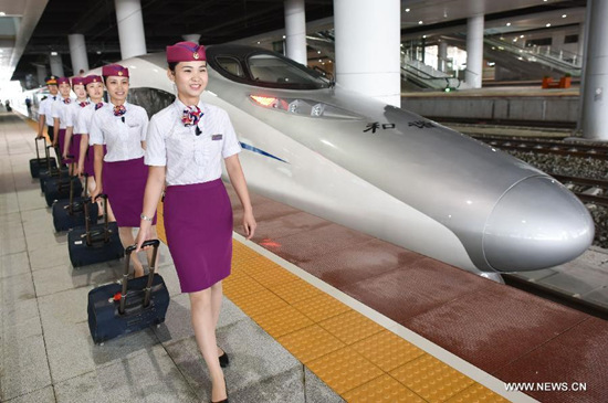Train attendants prepare to board a CH380 high-speed train at the Guiyang North Railway Station in Guiyang, capital of southwest China's Guizhou Province, June 17, 2015. The 286-kilometer-long Guiyang-Xinhuang section of the Shanghai-Kunming High-Speed Railway linking east China's Shanghai and Kunming, capital of southwest China's Yunnan Province, is scheduled to come on stream on June 18. (Xinhua/Liu Xu)