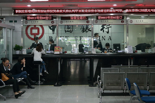 Customers waiting for banking transactions at a Bank of China Ltd branch in Guangzhou, Guangdong province. The lender has become the first Asian bank to join the auction process that sets gold prices in the London market. (Photo/China Daily)