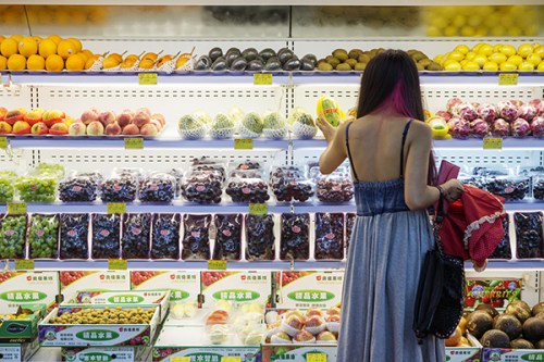 Looking for a healthy eating option. A customer stops at the fruit section of a supermarket in Beijing. (Photo/China Daily)