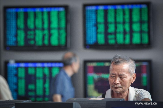 Investors look through stock information at a trading hall in a securities firm in Guiyang, capital of southwest China's Guizhou Province, June 29, 2015. (Photo: Xinhua/Ou Dongqu)