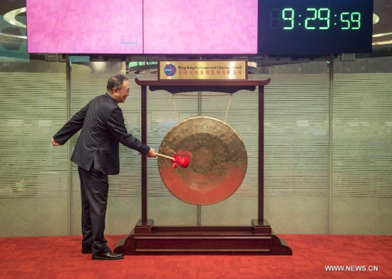 Liu Chuanzhi, founder and current chairman of Legend Holdings Corp., parent company of the world's largest PC maker Lenovo, strikes the gong at the listing ceremony of Legend Holdings Corp. at Hong Kong Stock Exchange in south China's Hong Kong, June 29, 2015. The Beijing-based investment company, which was founded in 1984, has its stock listed on Hong Kong Stock Exchange Monday. (Photo: Xinhua/He Jingjia)