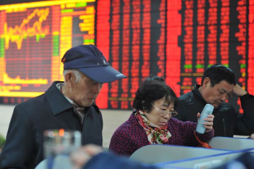 Investors examine share prices at a brokerage in Fuyang, Anhui province. An Xin/China Daily